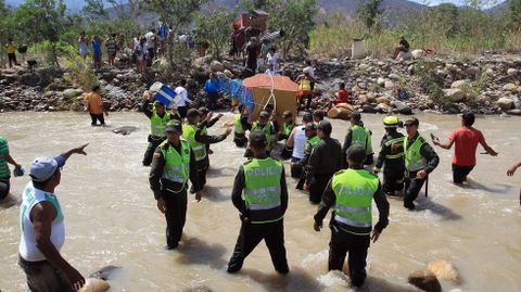 La Policía colombiana ha ayudado a los vecinos a cargar sus pertenencias por el río Táchira desde Venezuela.