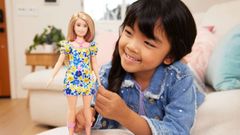 Imagen promocional de Mattel en la que una nia juega con la mueca
