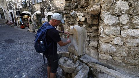 Un turista se refresca en Saint-Paul-de-Vence, en Francia.