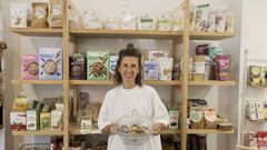 Idoia Caroza en su tienda, O Berce sin gluten, mostrando las galletas artesanales elaboradas en obradores de la zona.