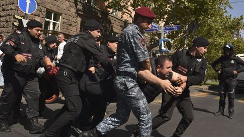 Policas armenios detienen a un hombre durante las protestas.