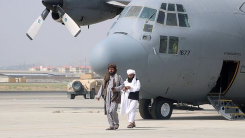 Los talibanes pasean frente a un avin militar tras la retirada de las tropas estadounidenses del aeropuerto de Kabul