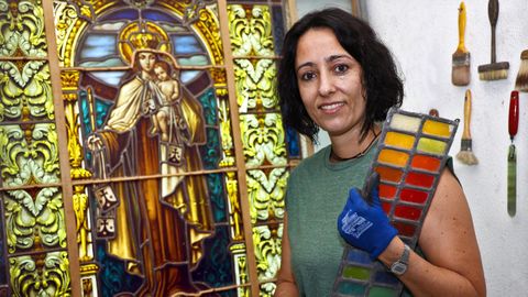 Cristina Molares, en su taller de Vidrieras Cosmo junto a una vidriera que está restaurando