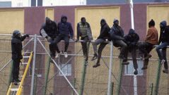 Una veintena de inmigrantes subidos a la valla de Mellilla en febrero del 2015