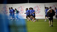 Los jugadores del primer equipo calientan antes de comenzar un entrenamiento