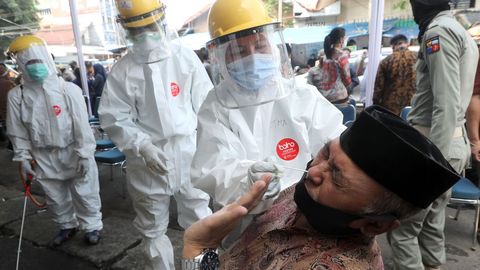 En Bogor, Indonesia, personal sanitario practica la prueba del coronavirus a un hombre