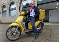 Jos� Canedo, cartero de profesi�n, sobre una moto de reparto de Correos.