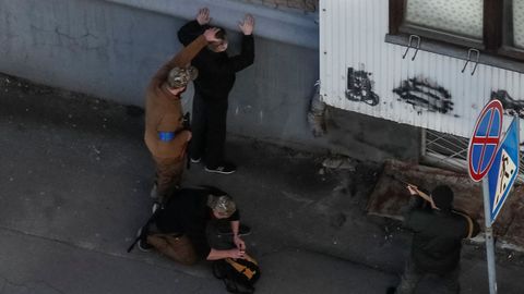 Milicianos de las fuerzas de Defensa registran a un hombre durante el toque de queda en Kiev