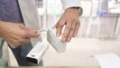 Un farmac�utico corta con un c�ter el cup�n de los f�rmacos