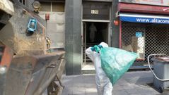 Una patrulla de limpieza retir� la basura acumulada en el edificio del 120 de la ronda de Nelle, en A Coru�a.