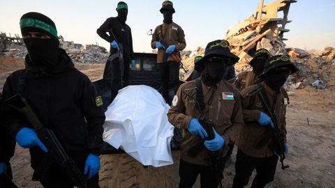 Militantes de Hams y de la Yihad Islmica esperan por los miembros de la Cruz Roja para entregar el cuerpo de uno de los rehenes israeles