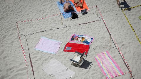 Los ba�istas tuvieron que convivir hoy con las parcelas hechas en las playas de Riazor y Orz�n, en A Coru�a, para la noche de San Juan. 