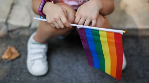 Una nia sostiene una bandera del arcoiris