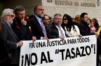 Un grupo de juristas sostiene una pancarta contra el tasazo ante los juzgados de Vigo.