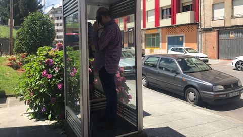 Un usuario, utilizando una cabina telef�nica en Pola de Siero
