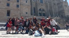 Un grupo de adolescentes y preadolescentes que participan en los proyectos de Cruz Roja en A Corua, tras completar el Camino de Santiago este viernes en la plaza del Obradoiro.