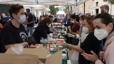 Vecinos de Paiporta se acercan a un punto de reparto de alimentos básicos.