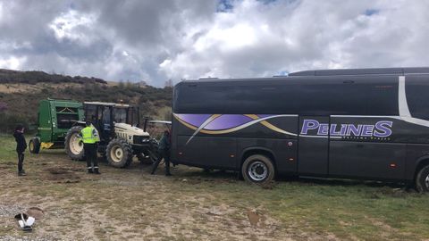 La Guardia Civil tuvo que sacar el autobs del barro usando el tractor de un vecino de la zona.