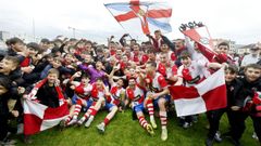 La plantilla de Arousa, celebrando su �xito junto a algunos de sus aficionados y la copa de campe�n del grupo gallego de la Tercera RFEF.