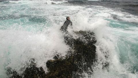 Imagen de archivo de de un percebeiro gallego en plena faena, luchando con las olas desde una roca