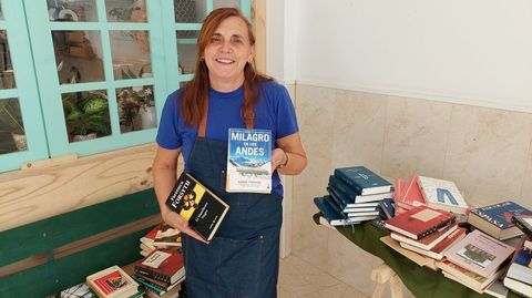 María Teresa Otero, con algunos de los títulos del servicio de préstamo gratuito de libros del mercado de Sanxenxo