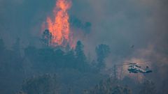 Un helicptero vuela cerca de las llamas en el condado de Napa, California.