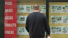Una persona observa los anuncios de viviendas en el escaparate de una inmobiliaria de la comarca.