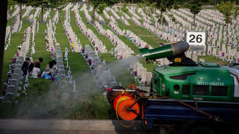 Un camión fumigador desinfecta un cementerio en Seúl