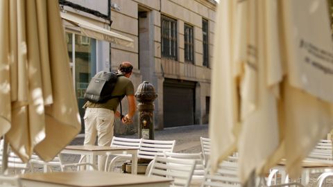 Un hombre se refresca en una fuente p�blica en Lugo