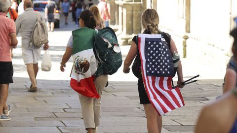 Dos peregrinas con las banderas de M�xico y Estados Unidos enfilando esta semana la r�a do Franco