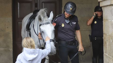 La seguridad se refuerza en Santiago con patrullas a caballo. Una de ellas recibe el saludo de una turista en el casco histórico