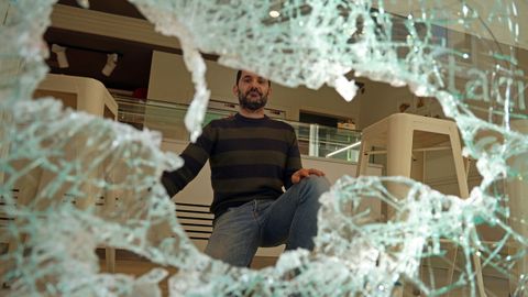 Enrique Casta�o, gerente de la confiter�a Dominga muestra los da�os en el escaparate de su tienda de Ribeira