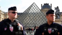 Miembros de la policía francesa frente a la pirámide de cristal del Louvre tras conocerse las primeras detenciones por el robo de joyas