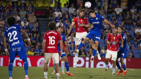 Duelo a�reo en la segunda parte del Getafe-Celta entre el defensa celeste Javi Rueda y el centrocampista azul�n Mario Mart�n.