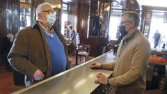 Un cliente le muestra su certificado a Emilio V�zquez, propietario del caf� Avenida de Ferrol