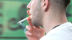 Hombre fumando en la calle.