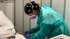Una sanitaria atiende a un paciente en un hospital de Barcelona