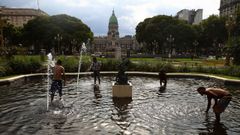 Varios viandantes se refresca en una fuente p�blica de Buenos Aires, cerca del Congreso Nacional.