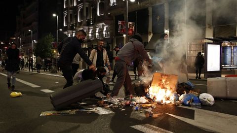 Varios participantes en las protestas incendian cubos de basura en la Gran Via de Madrid