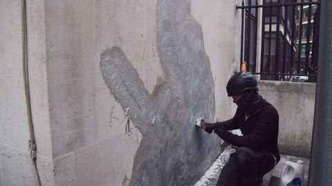Un trabajador borra el ltimo trabajo de Banksy en los Reales Tribunales de Justicia de Londres
