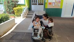 Aldn, a la salida de su escuela en Tabeaio, con su madre Pilar Grande y su hermana.