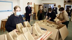 Usuarios de Aspanane y directivos de EV, al fondo, con cantoneras de cart�n que montan