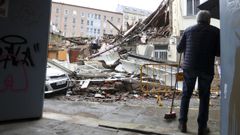 Un vecino de Esteiro barriendo la entrada de su casa ante los escombros 