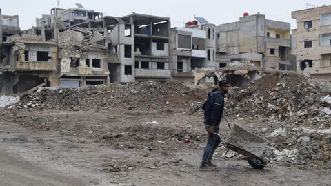 Un hombre retira escombros cerca de un colegio en Jalidiya.
