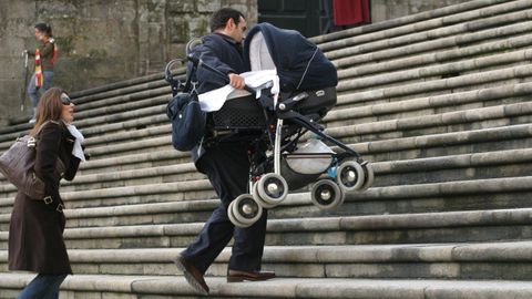 Una pareja sube en brazos el carrito de un beb� por unas escaleras en Santiago