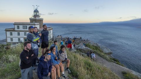 Turistas disfrutan del atardecer junto al faro de Fisterra