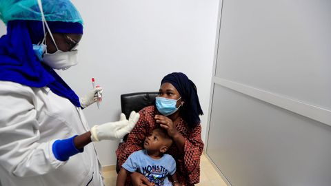 Una mujer y su hijo escuchan a una sanitaria que les realizar� la prueba para detectar el covid-19 en Dakar, Senegal