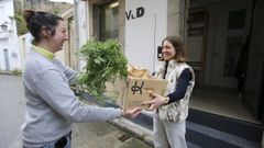 Laura, empleada de kibus.online, entrega un pedido de fruta y verdura a Cristina Agull�, una joven de Ferrol Vello que se ha hecho clienta del mercado a ra�z de la puesta en marcha del servicio