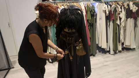 Olga Durn, encargada de Moda y Complementos, colocando uno de sus trajes de meiga.