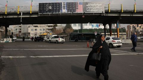 Una mujer pasa delante de un cartel contra Estados Unidos en Teher�n